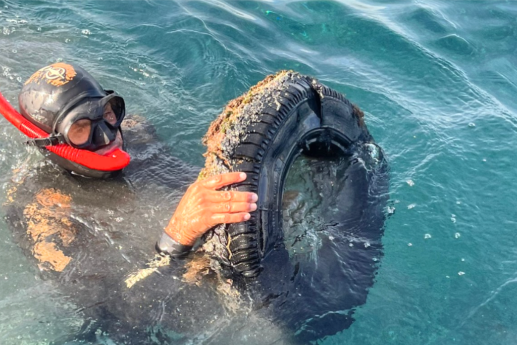 Diver removing a tyre from the sea